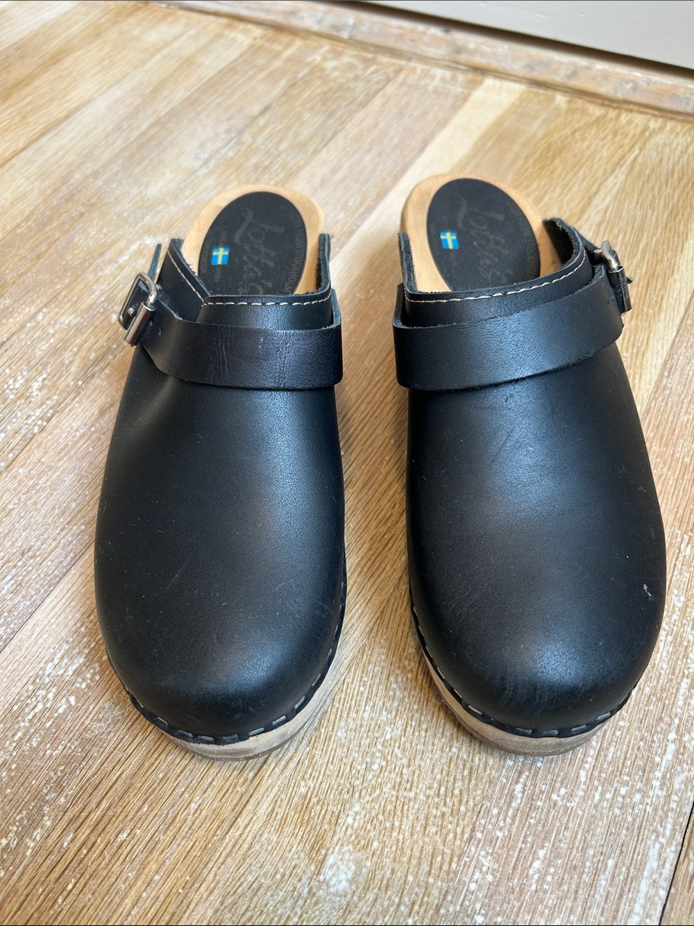 Lotta’s Black Leather Clogs with Buckle Strap